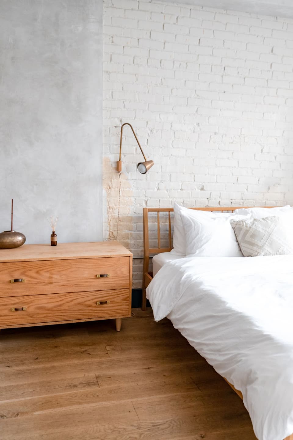 A cottage bedroom, white brick and white linen
