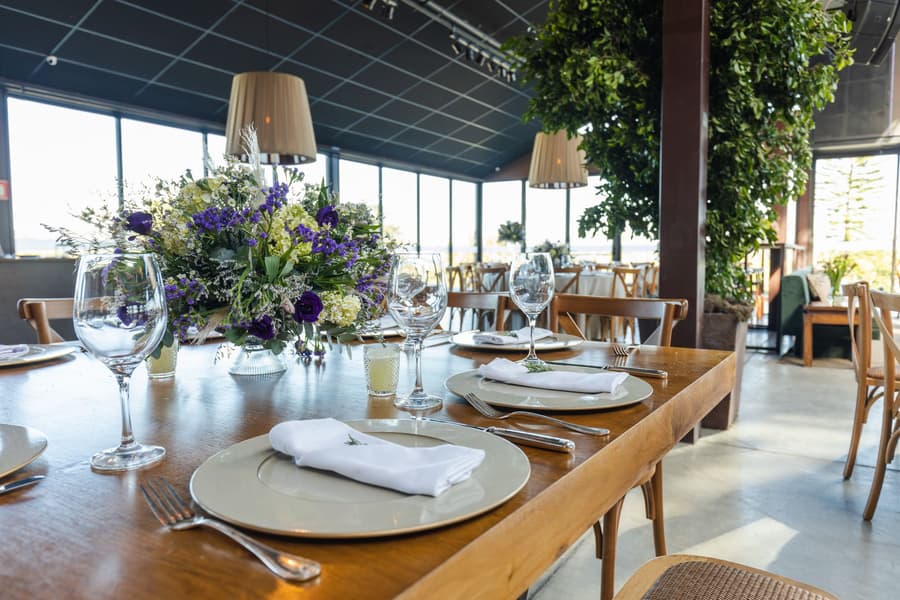 A set table in the grain store, flowers and glassware