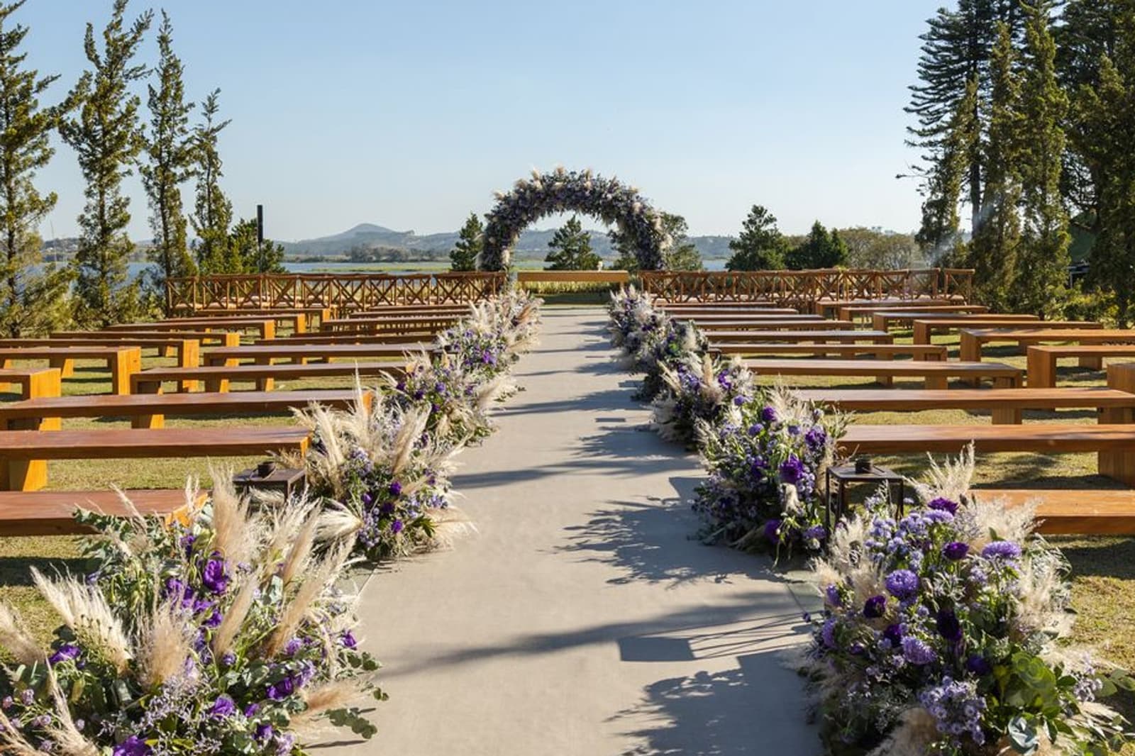 The aisle between timber benches and flowers, the arch at the end