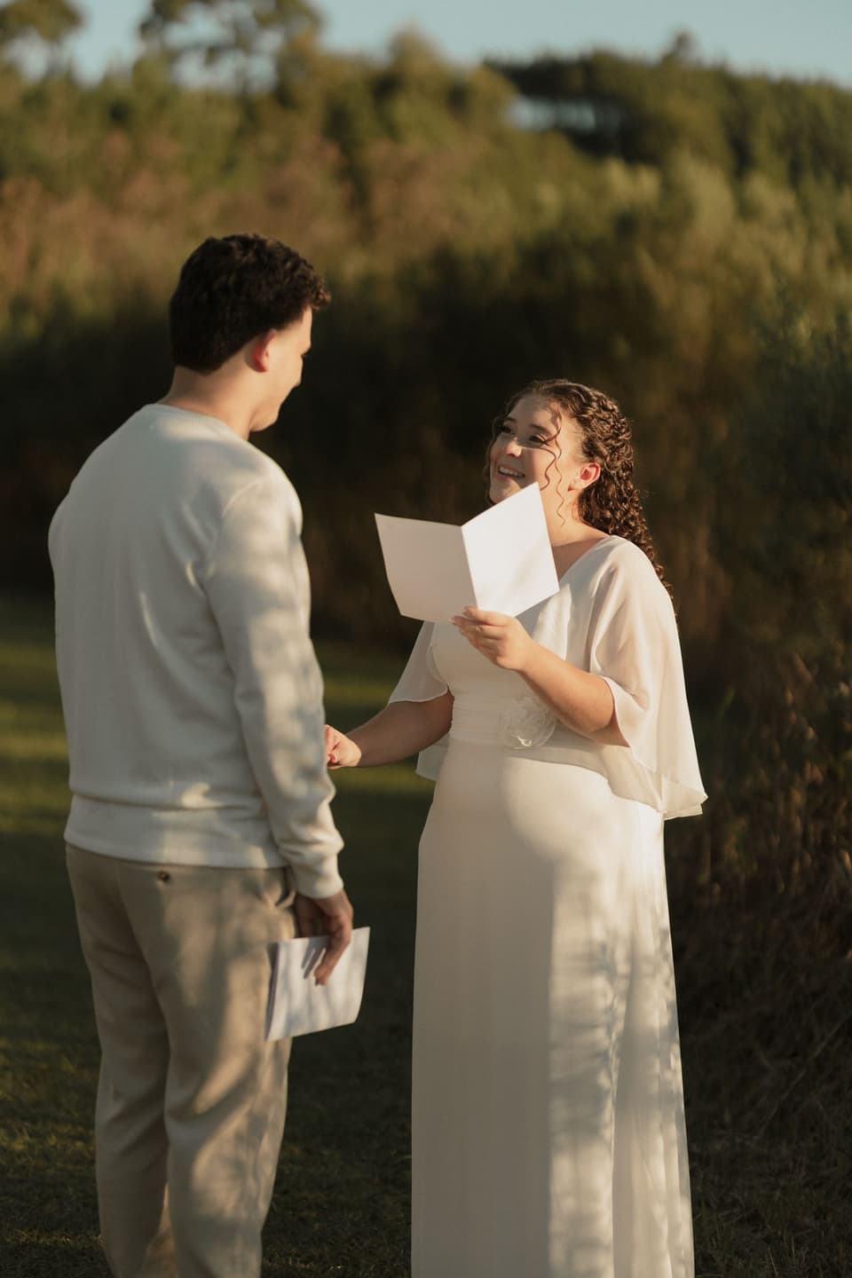 Grace and Ollie reading their vows to each other on the lawn